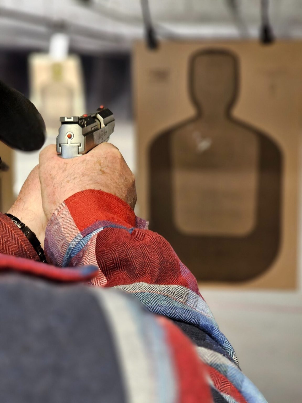 Student on the firing line taking aim at a paper target during a Michigan CPL class
